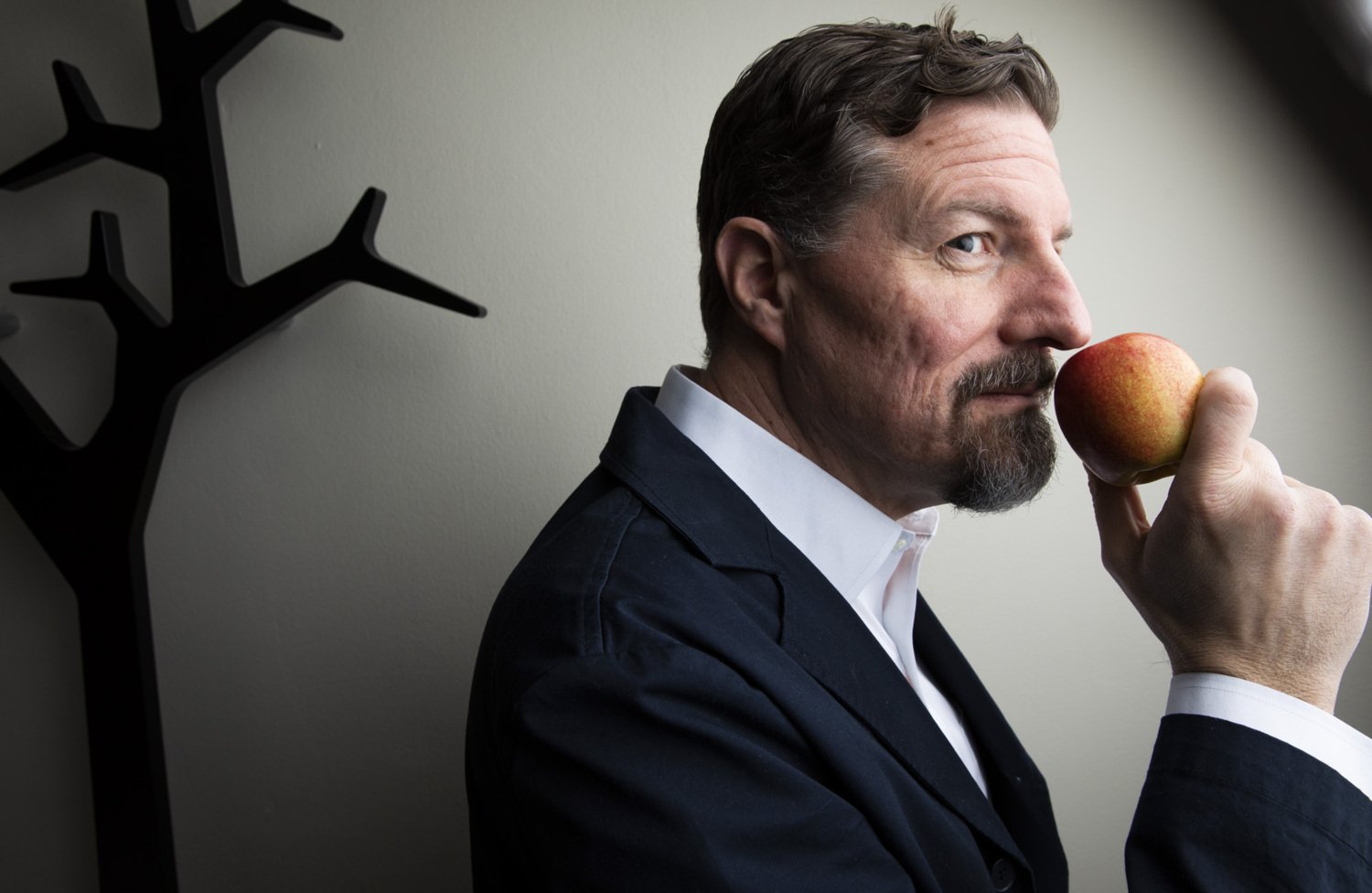 Professorn Johan Lundström håller ett äpple mot näsan.