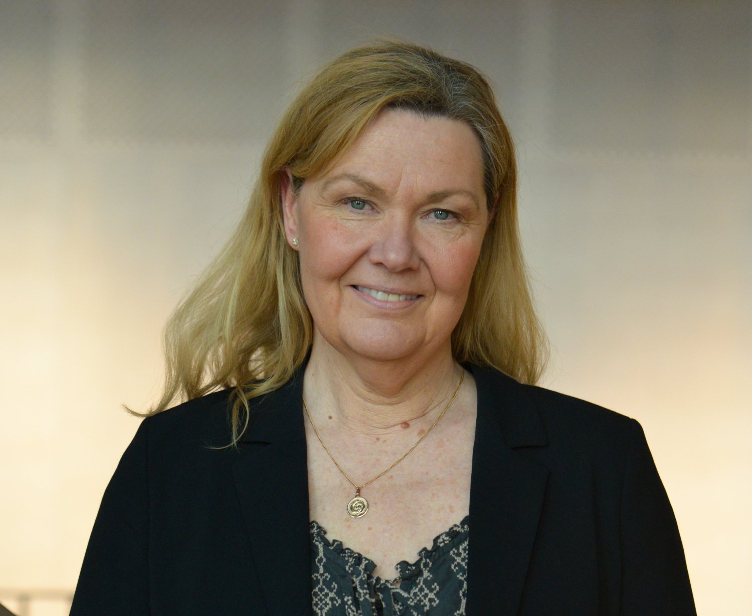 Porträtt av kvinna i svart kavaj.