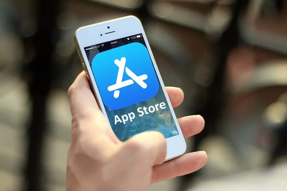 Person håller iphone där det står AppStore och logga.