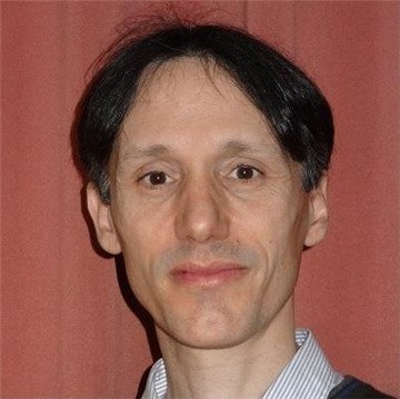 A portrait of Matteo Bottai against a brick red wall.