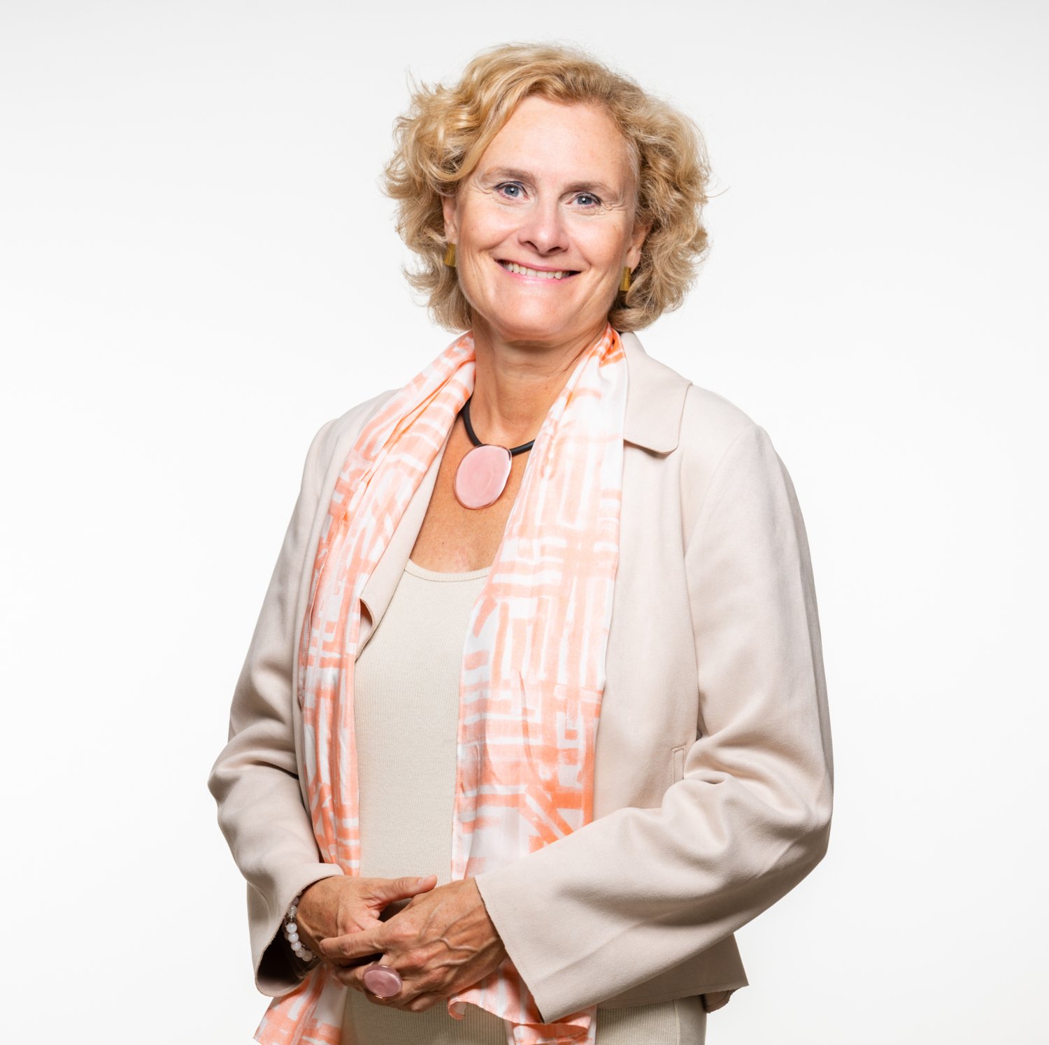 Portrait of Ellenor Mittendorfer-Rutz. She is wearing a jacket in soft pink and is standing in front of a bright backdrop.