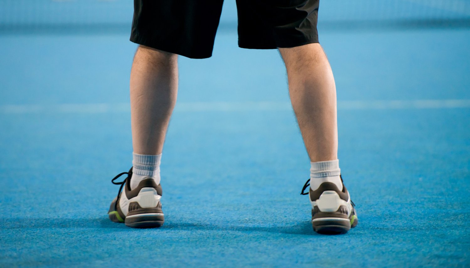 Fötter på tennisbana