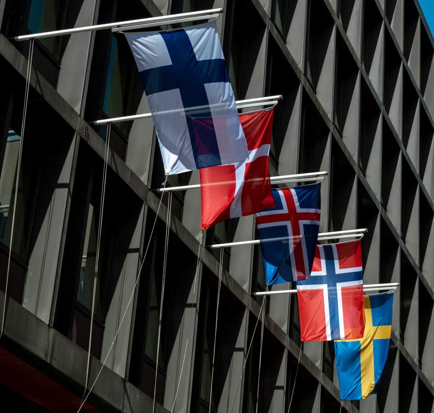 The Finnish, Danish, Icelandic, Norwegian and Swedish flags hanging off a building