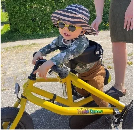 bebis med solglasögon på en gul cykel