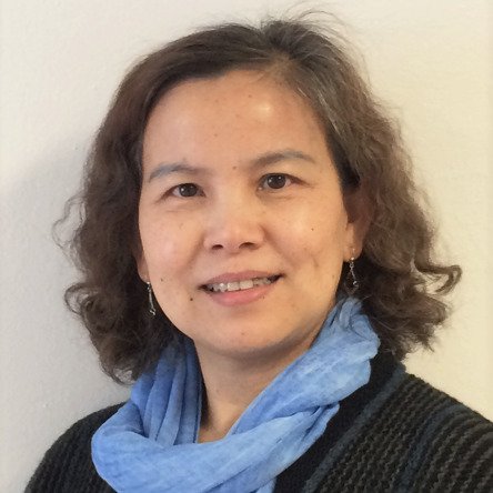Porträtt av Ping Qin som bär en ljusblå sjal och en svart kofta.