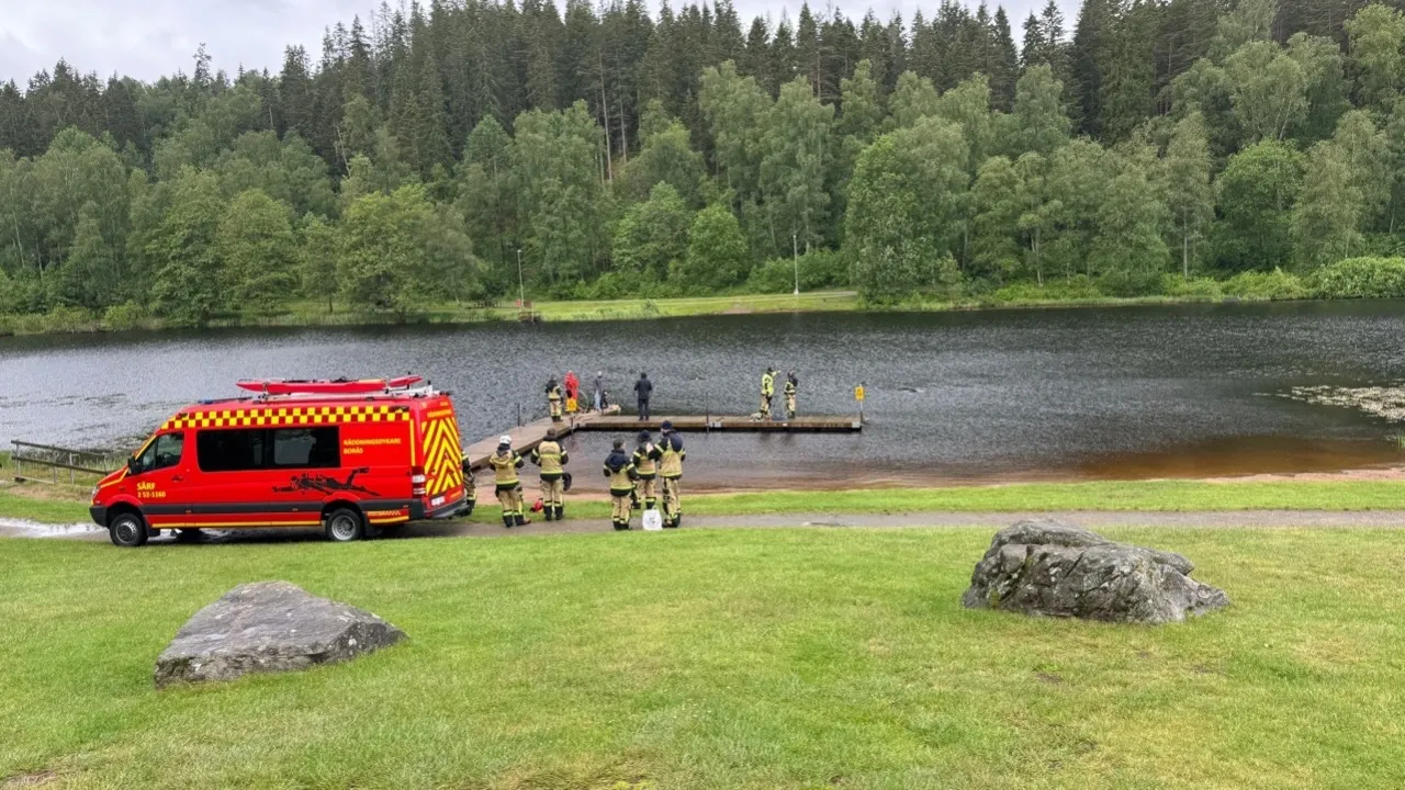 Ambulansbil på gräsmatta vid vatten.