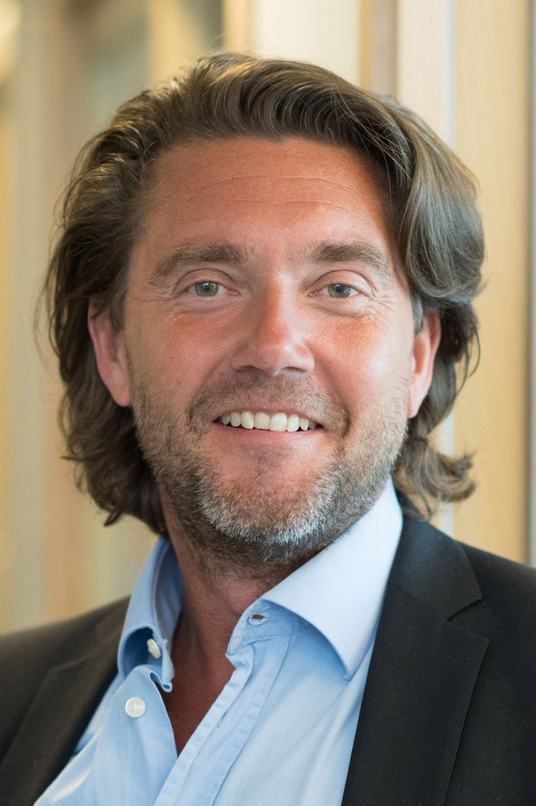 Portray of Mikael Rydén, dressed in shirt and jacket, in hospital environment.