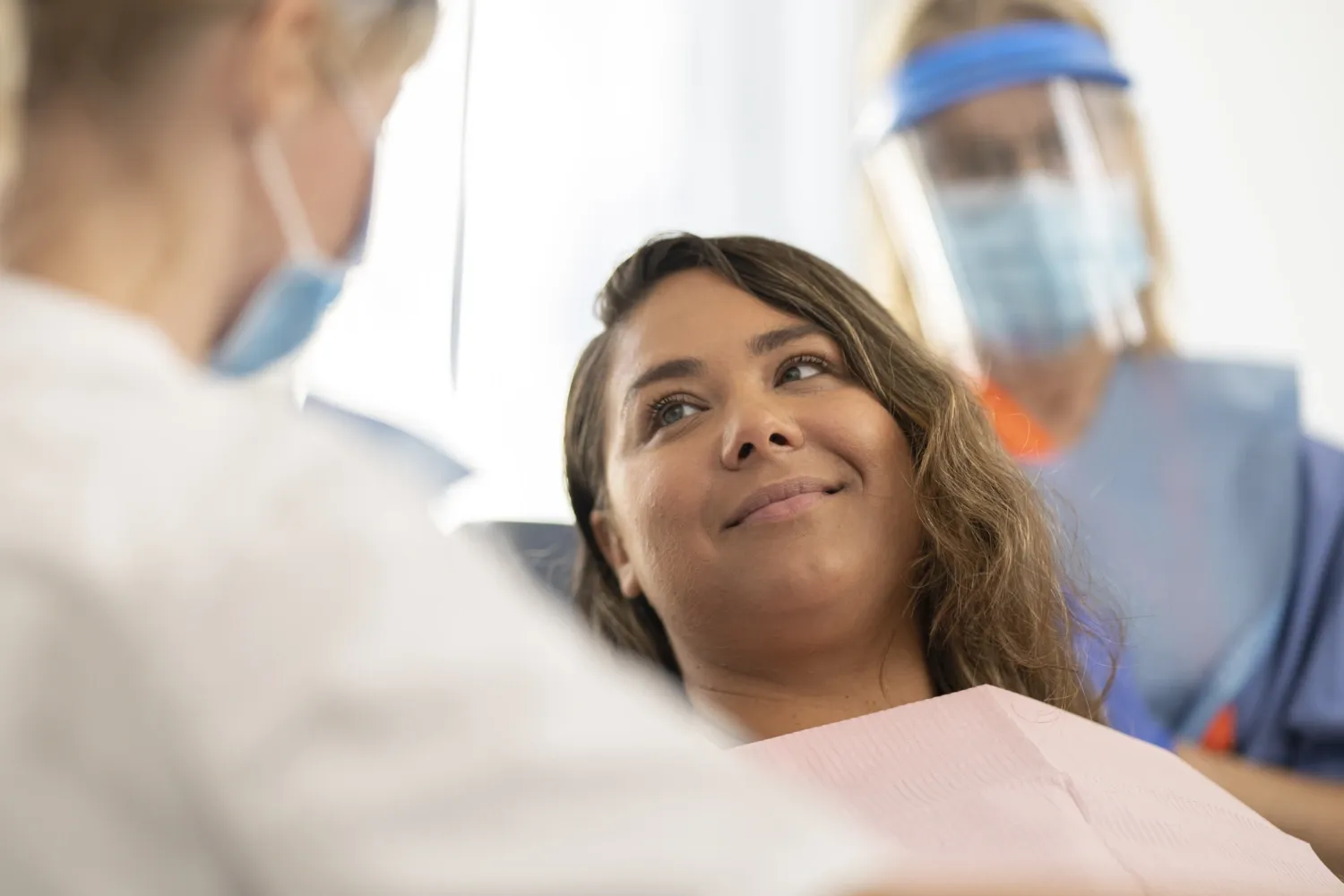 Dental treatment, patient in the chair with dentist and detnal nurse.
