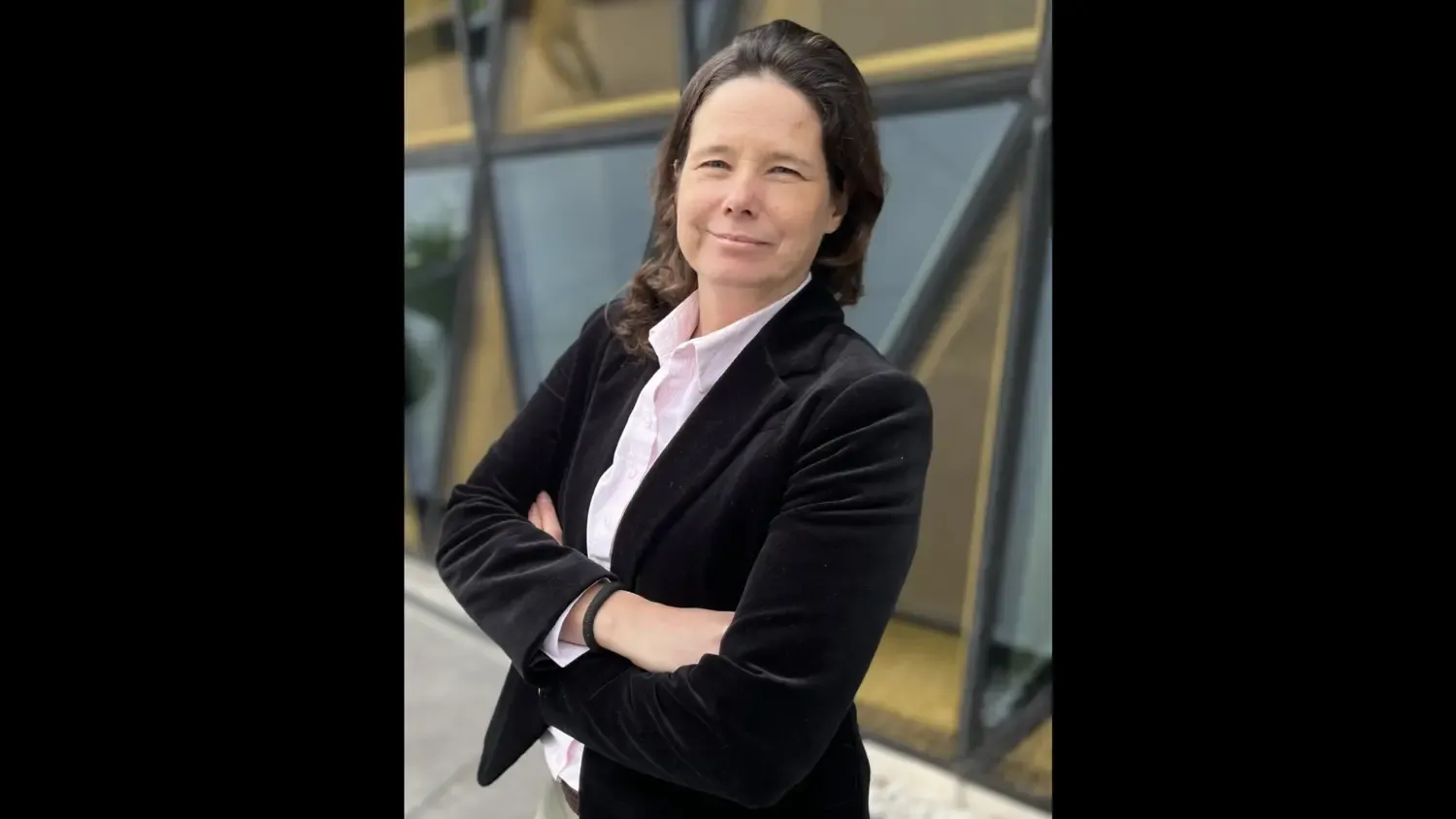 Profile photo of a woman with brown hair wearing a white shirt and black blazer