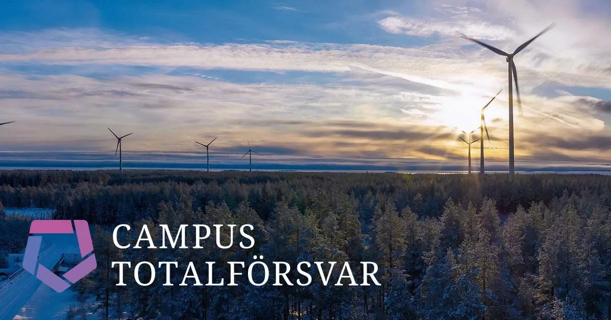 Vy över ett vintrigt landskap med skog och vindkraftverk