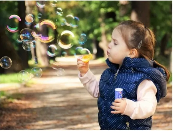 Child blows bubbles