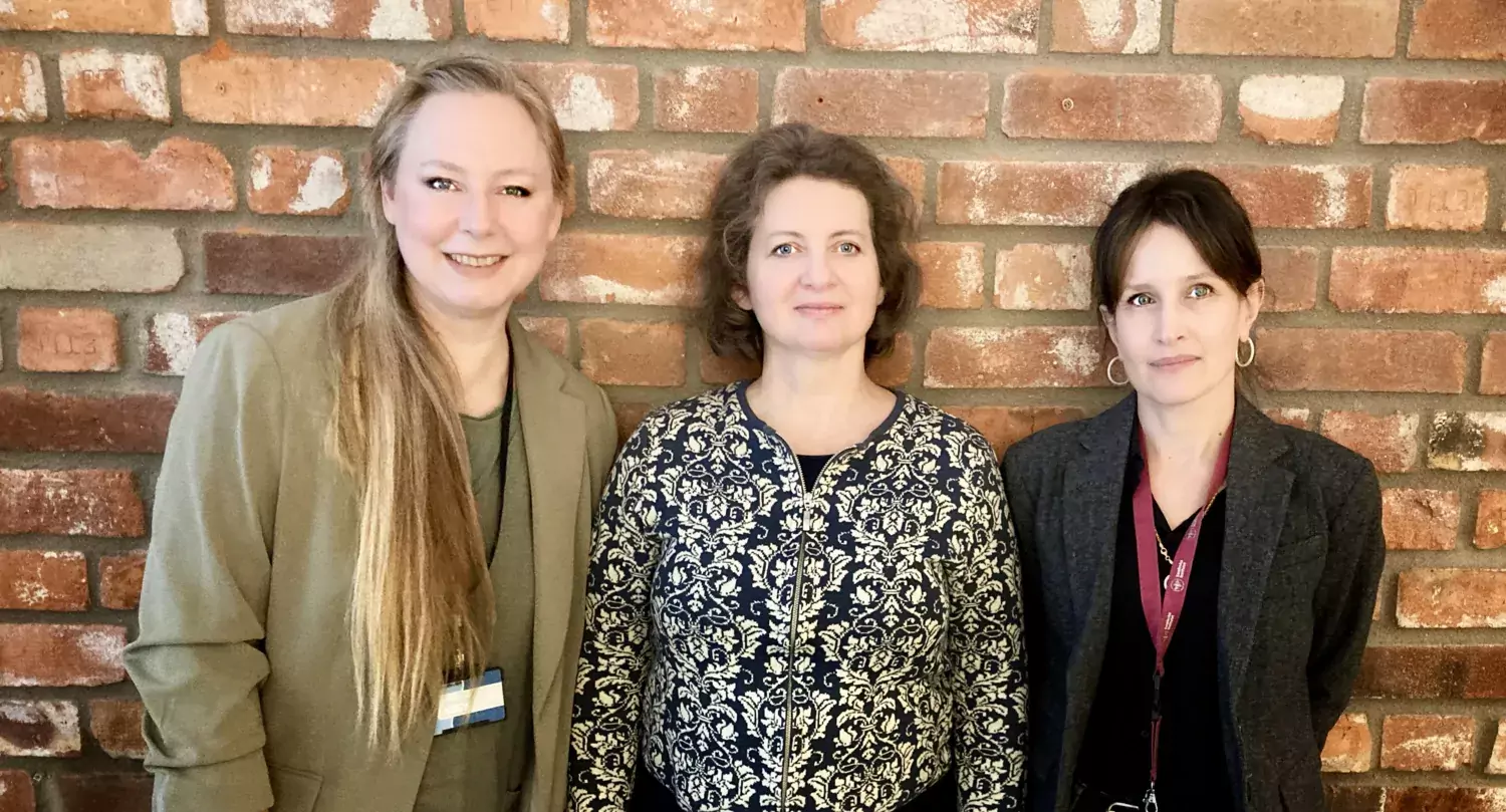 Portrait of Annica Gad, Katalin Dobra and Joanna Zawacka-Pankau standing in front of a brick wall.