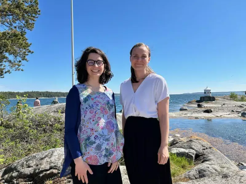 A picture of two women in an archipelago setting. The women look into the camera and smile.