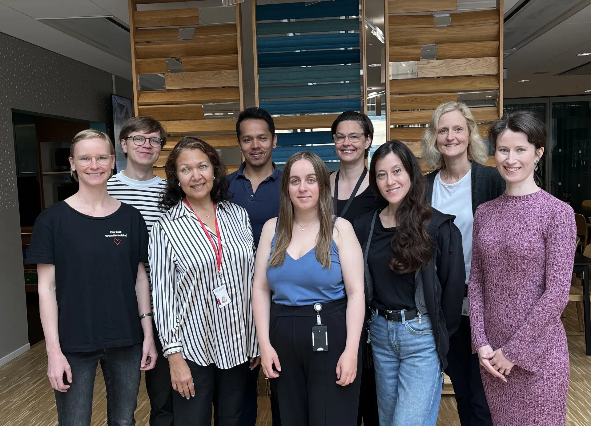 Gruppbild på nio personer i inomhusmiljö.