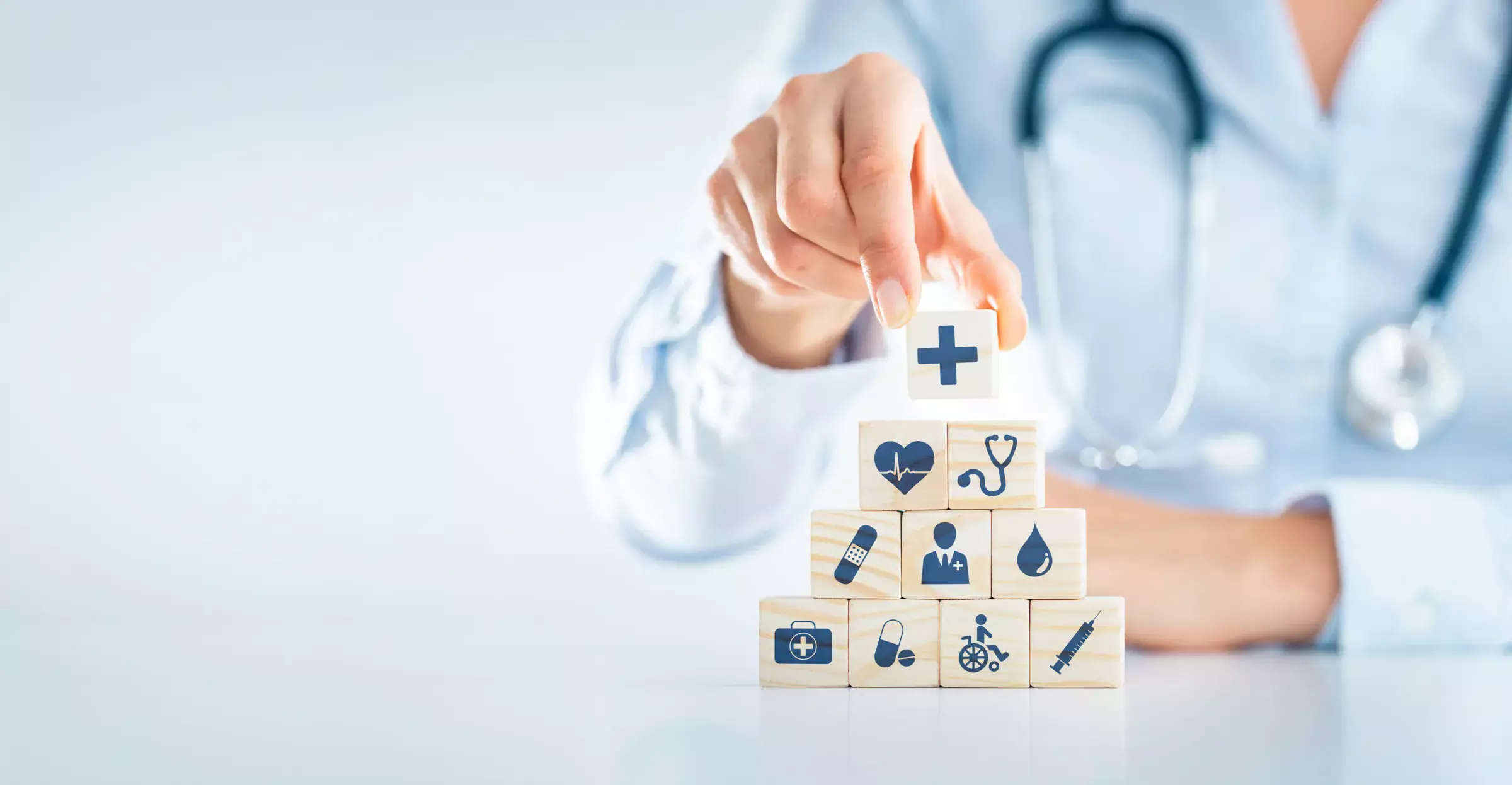 Blocks with icons representing health and healthcare stacked on top of each other like a pyramid.