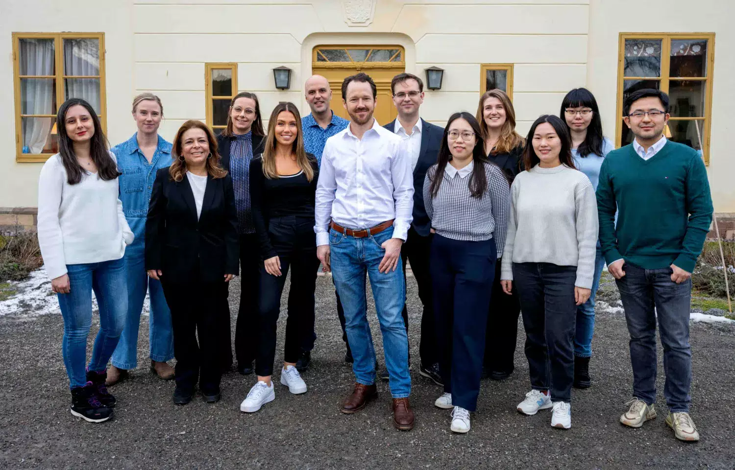 Medlemmarna i Johan Hartmans forskargrupp står uppställda framför ett hus.