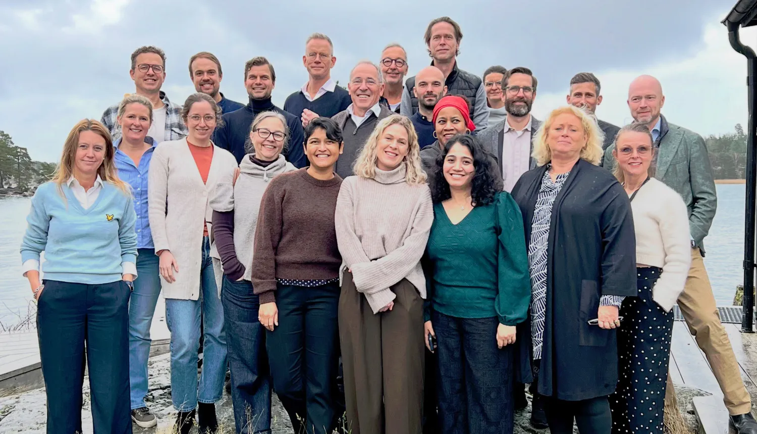 Gruppbild med 22 glada personer på en klippa utomhus