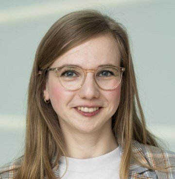 Porträtt av kvinna i ljus tröja och kavaj.