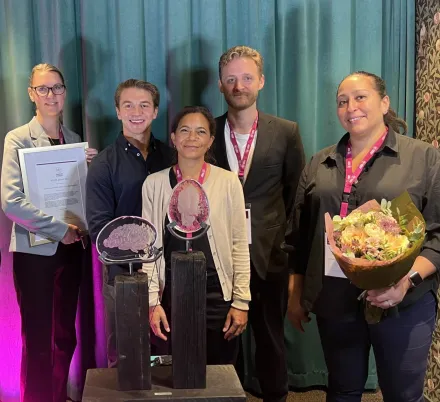 Fem medarbetare vid Optikerprogrammet och S:t Eriks Ögonsjukhus som håller i prisstatyett och blommor.