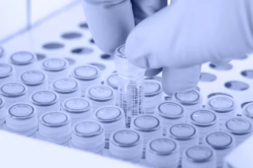 Scientist removes a test tube. Gloved hand. Light blue tint applied to image.