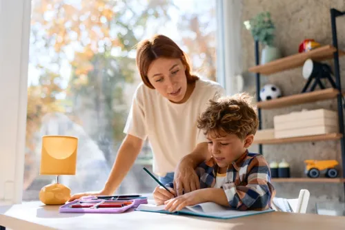 A mother helping her son doing his homework