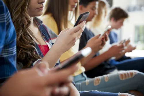 Teenagers looking at their mobile phones
